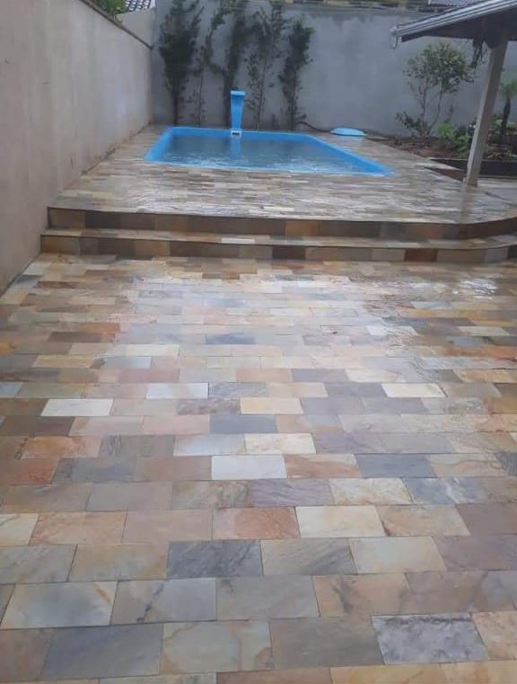 Deck de pedra com degrau em volta de uma piscina pequena